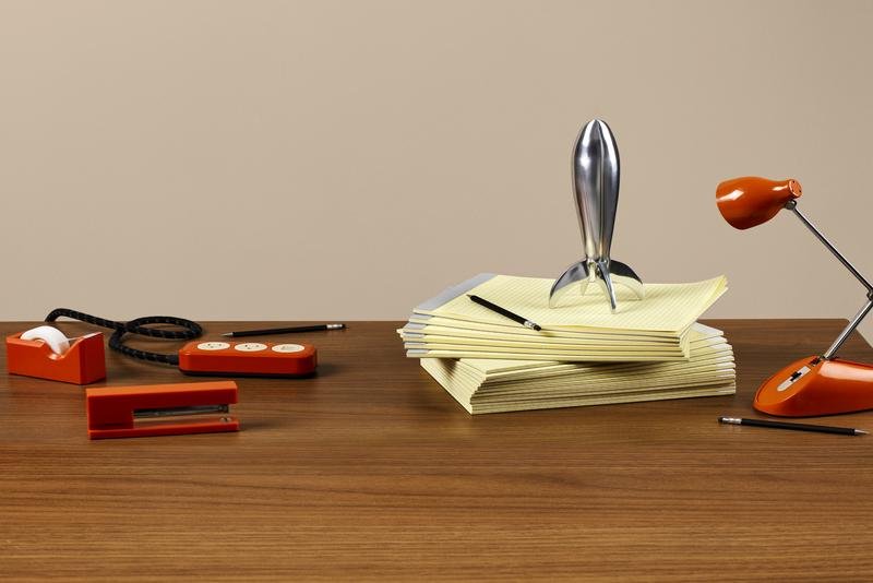 A silver rocket ship on a stack of yellow legal pads