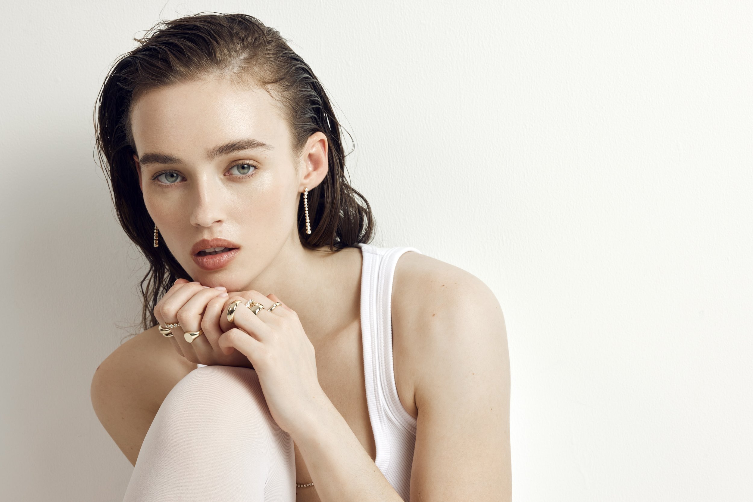 Close-up of ear with gold hoop earrings