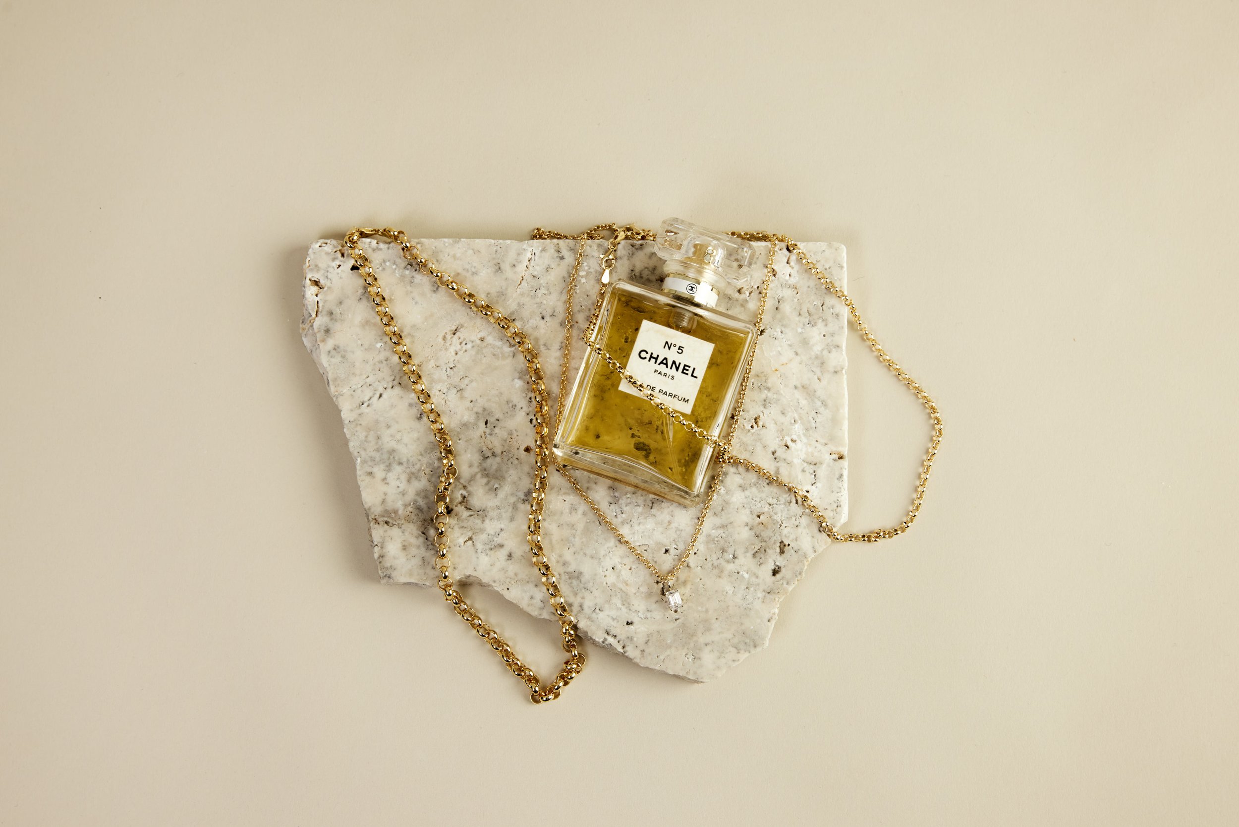 Close-up of a person wearing two delicate gold necklaces.