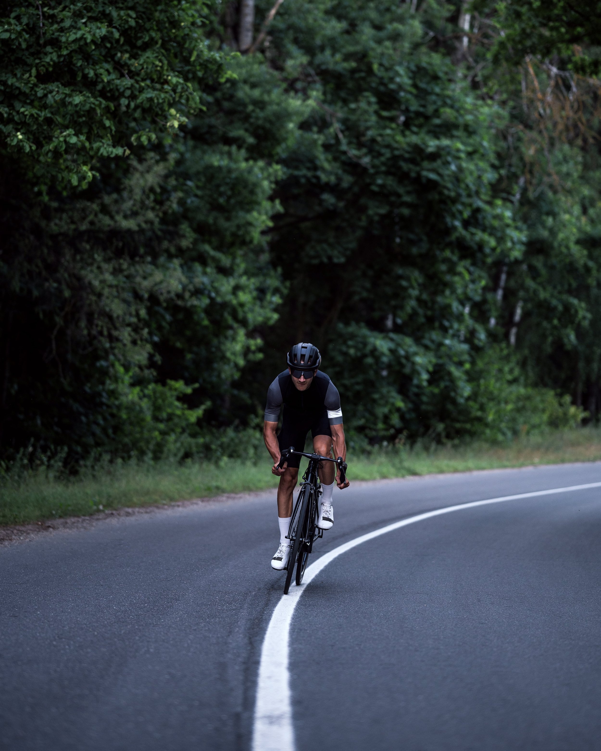 A powerful cyclist accelerates down the road