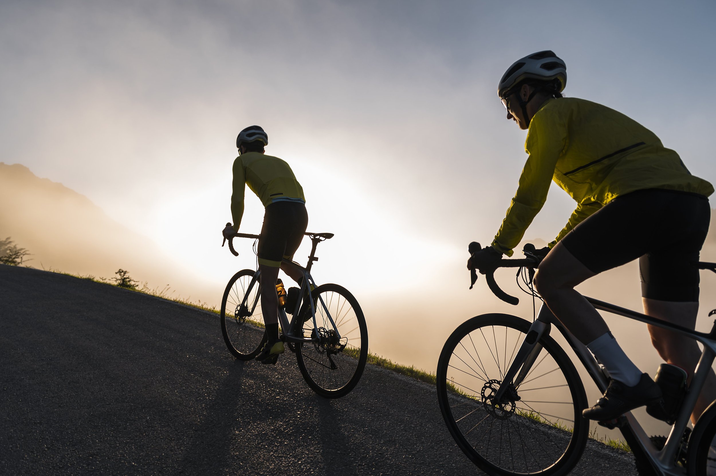 Friends together cycling on misty morning